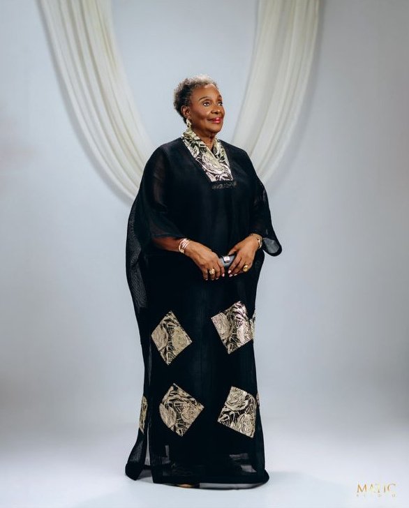 Chief Mrs. Josephine Chinyelu Nwosu standing in a black outfit with patterned details.
